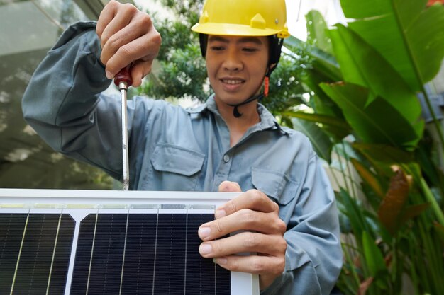 Smiling builder preparing solar panel for installation