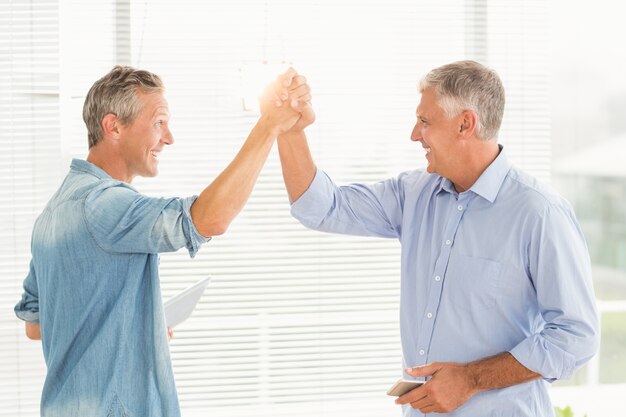 Smiling business colleagues giving high-five