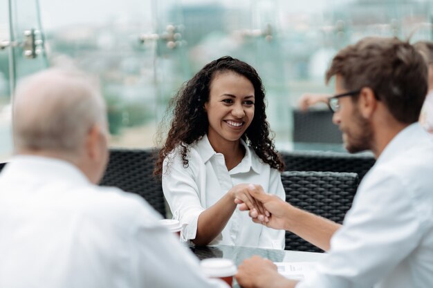 Colleghi di lavoro sorridenti che si stringono la mano da vicino