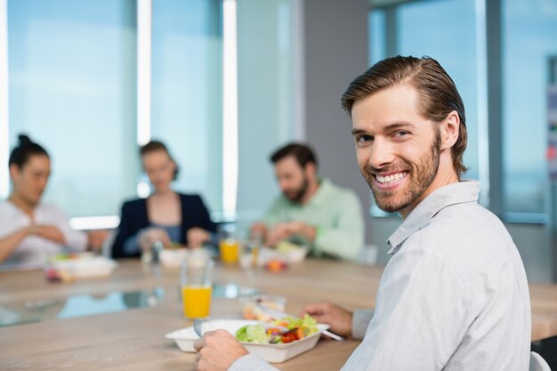 Smiling business executive having meal in office