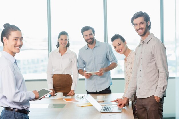 Smiling business executives standing in conference room