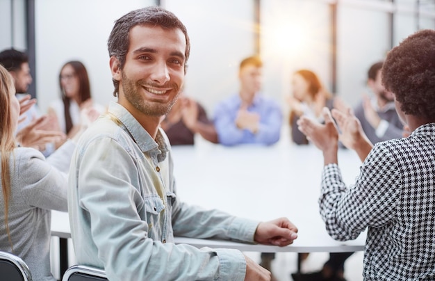 Smiling business group of office workers executive board members or employees looking at camera sitt