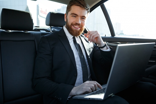 Photo smiling business man with laptop