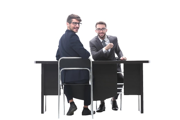 Smiling business partners sitting at the table and looking at the camera