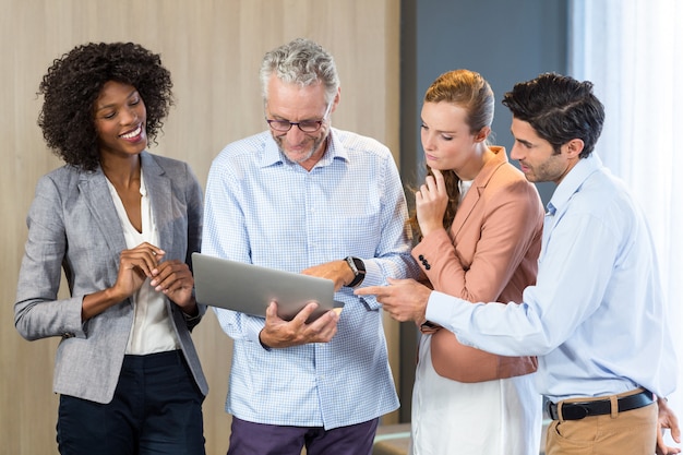 Smiling business people discussing over laptop