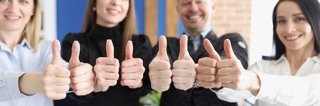 Photo smiling business people show thumbs up gesture stand in office