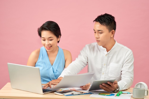 Smiling business people using a computer in their office