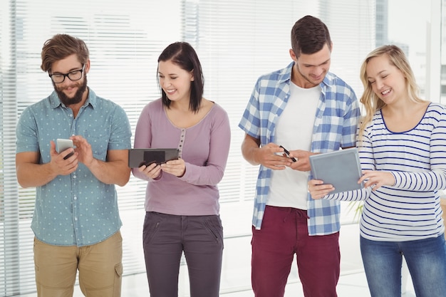 Smiling business people using electronic gadgets 