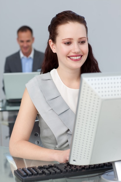 Smiling business people working at computers 