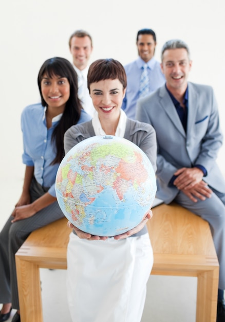 Smiling business team holding a terrestrial globe