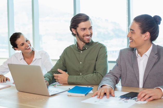 Smiling business team interacting with each other in conference room