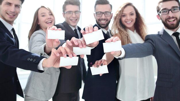 Foto squadra sorridente di affari che mostra i loro biglietti da visitaconcetto di cooperazione