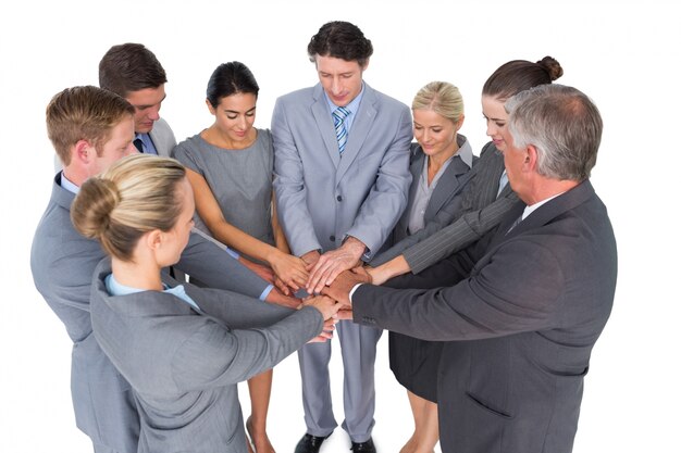 Smiling business team standing in circle hands together