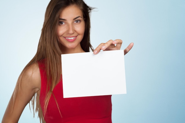 Smiling business woman handing a blank business card