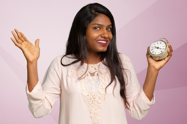 Smiling business woman holding alarm clock. 