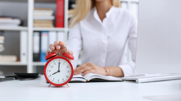 Smiling business woman holding in hand clock