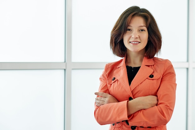 Smiling business woman in modern office on white background crossed arms