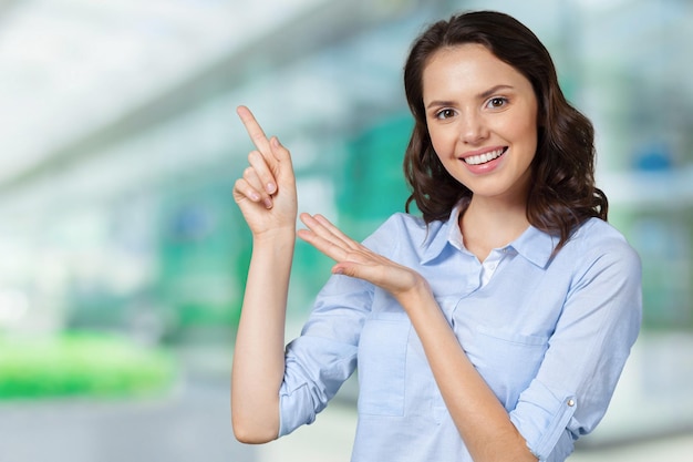 Smiling business woman pointing finger