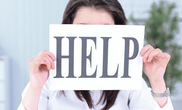 Smiling business woman showing a sheet with the word help