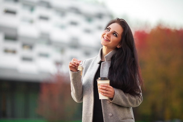 Smiling business woman with keys over office room or new apartment 