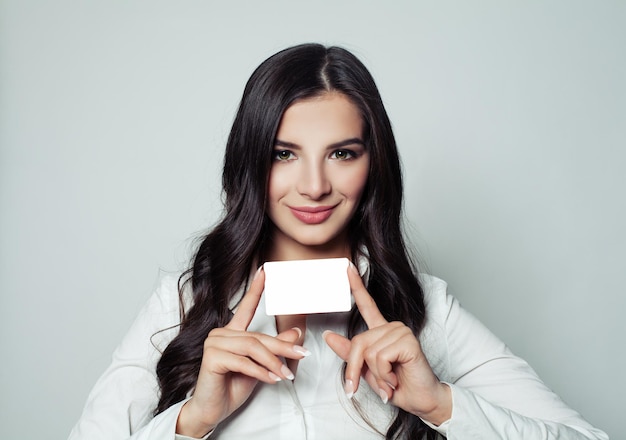 Smiling business woman with white blank card business and education concept