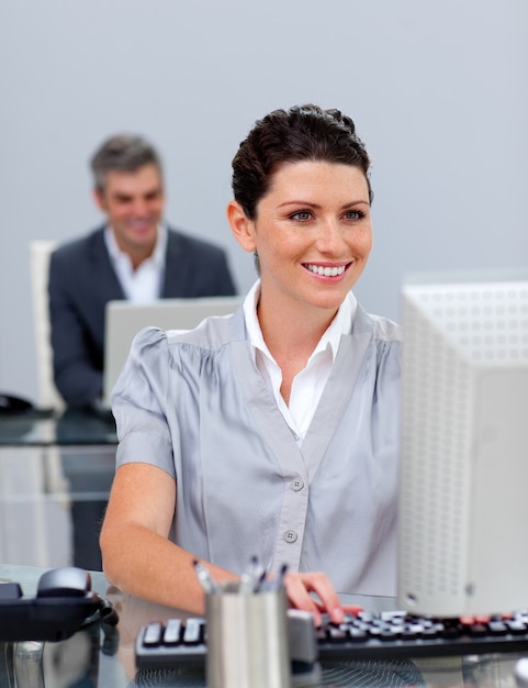 Улыбаясь деловая женщина, работающая на компьютере