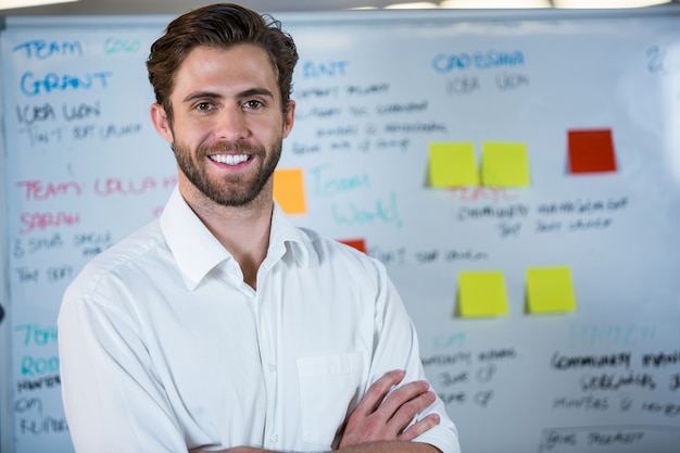 Smiling businessman against whiteboard