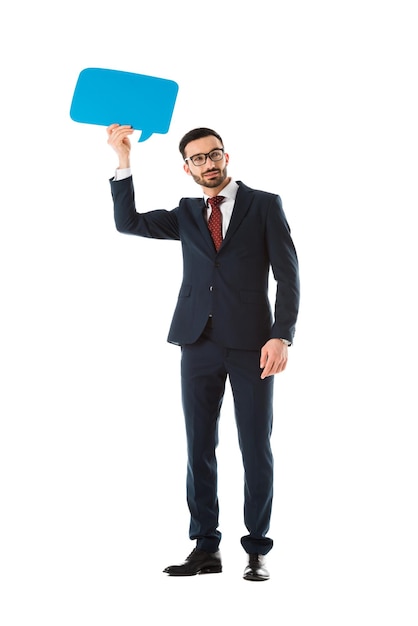 Smiling businessman in black suit holding speech bubble above head isolated on white