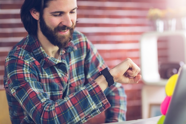 Smiling businessman checking time  