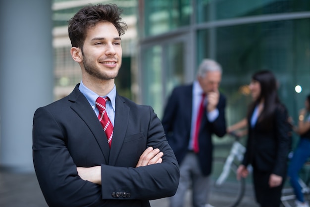 Smiling businessman in front of a blue glass background