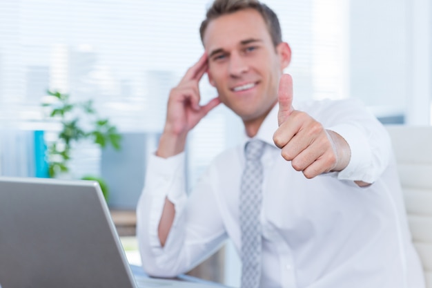 Smiling businessman gesturing thumbs up