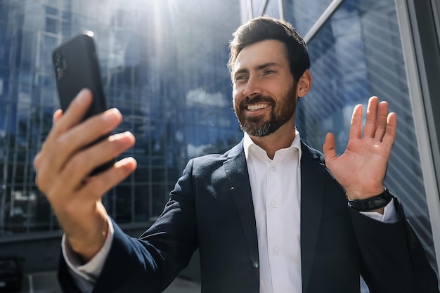 Smiling businessman greeting someone and smiling