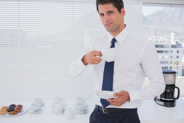 Smiling businessman having a coffee during the break