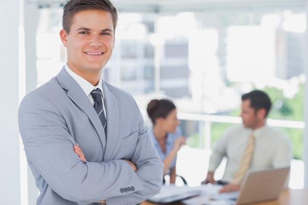 Smiling businessman and his colleagues in background