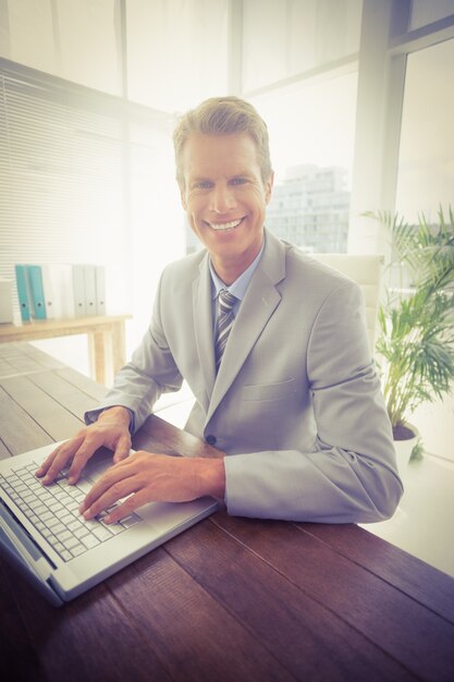 Foto uomo d'affari sorridente nel suo computer portatile