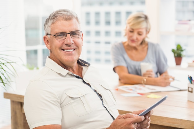 Smiling businessman holding a digital tablet