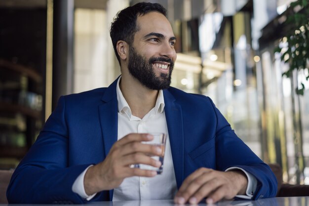 Smiling businessman holding a glass of water