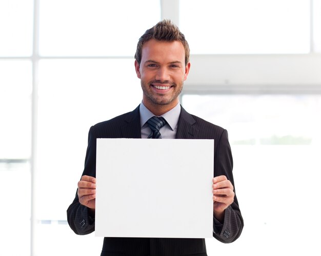 Smiling businessman holding a white card