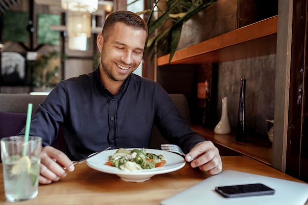 写真 笑顔のビジネスマンはレストランで昼食をとっています