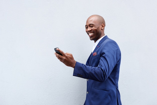 Smiling businessman looking at cellphone 