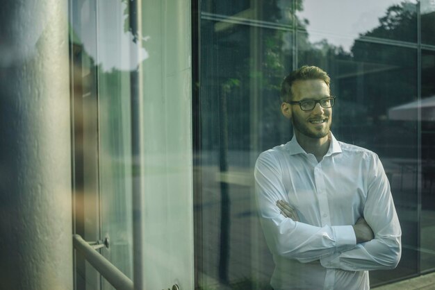 Smiling businessman looking out of window