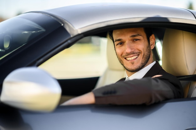 Foto un uomo d'affari sorridente in un'auto di lusso.