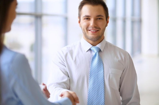 Foto l'uomo d'affari sorridente in ufficio sta stringendo la mano al suo partner