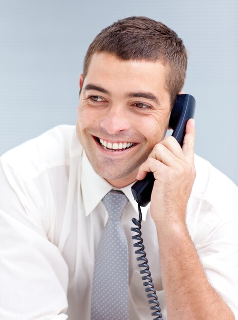 Smiling businessman in office talking on phone