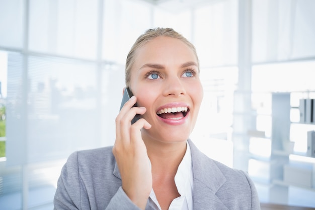 Smiling businessman phoning at her desk 