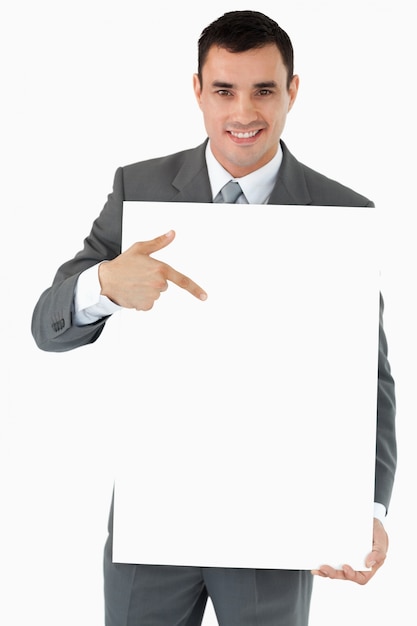 Smiling businessman pointing at the sign in his hands