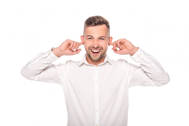 smiling businessman putting fingers in ears isolated on white