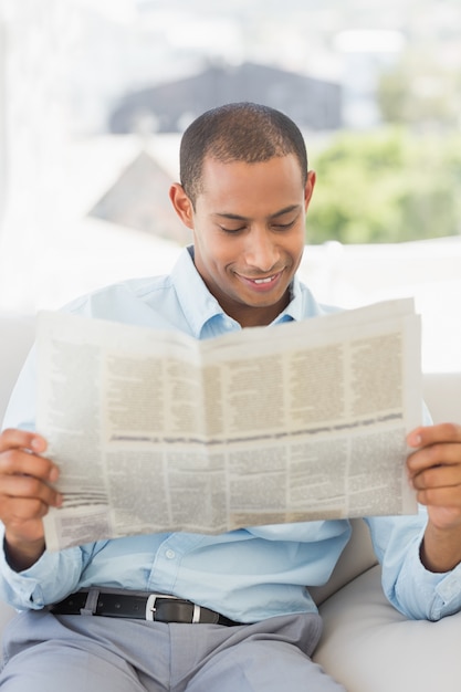 Foto sorridente uomo d'affari che legge il giornale sul divano