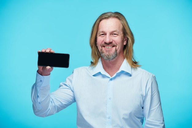 Smiling businessman showing the screen of smartphone