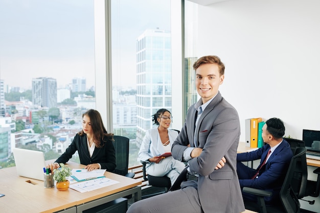 Smiling businessman sitting on desk